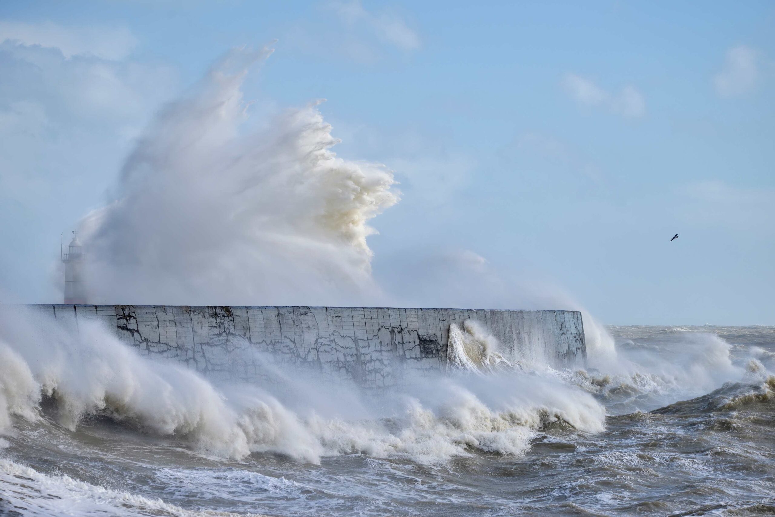 Massive waves crash over harbour wall onto lighthouse during huge storm on English coastline in Newhaven, amazing images showing power of the ocean